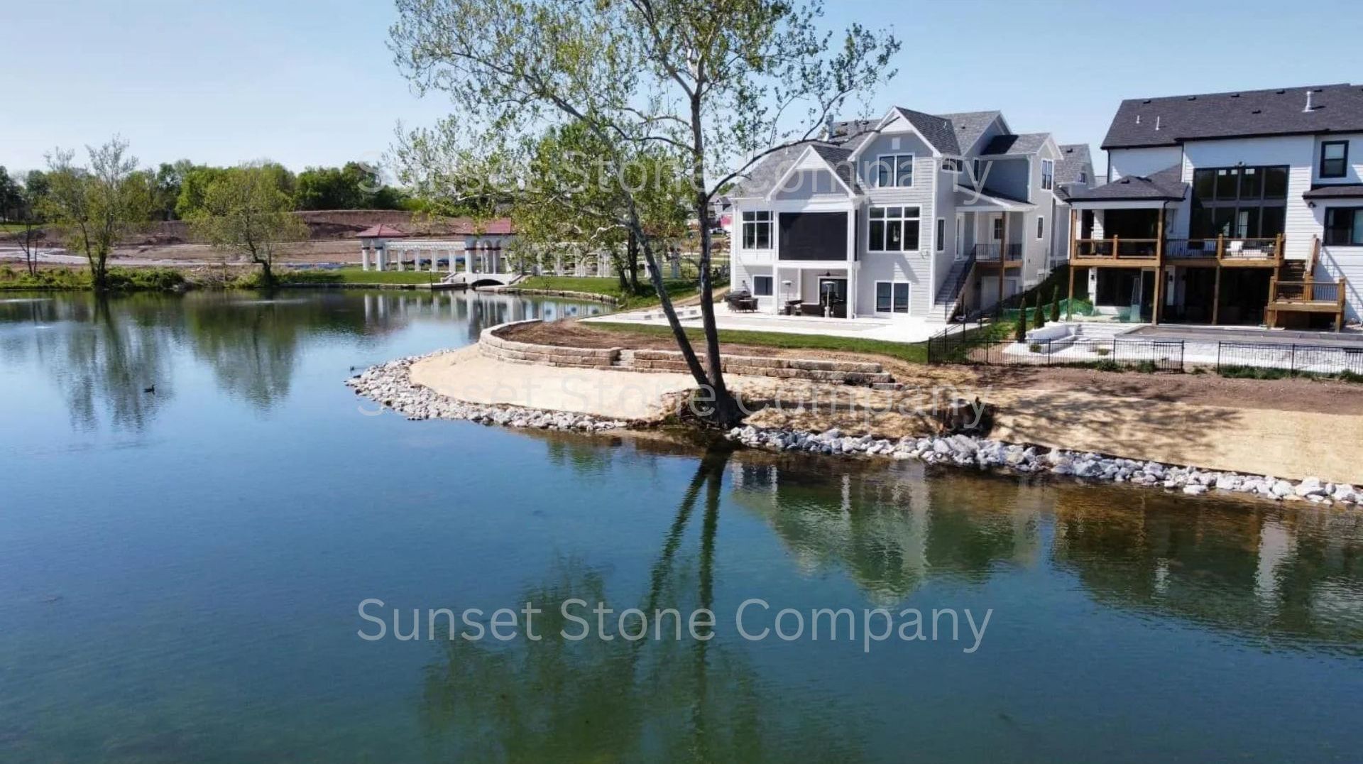 A large house is sitting on the shore of a lake