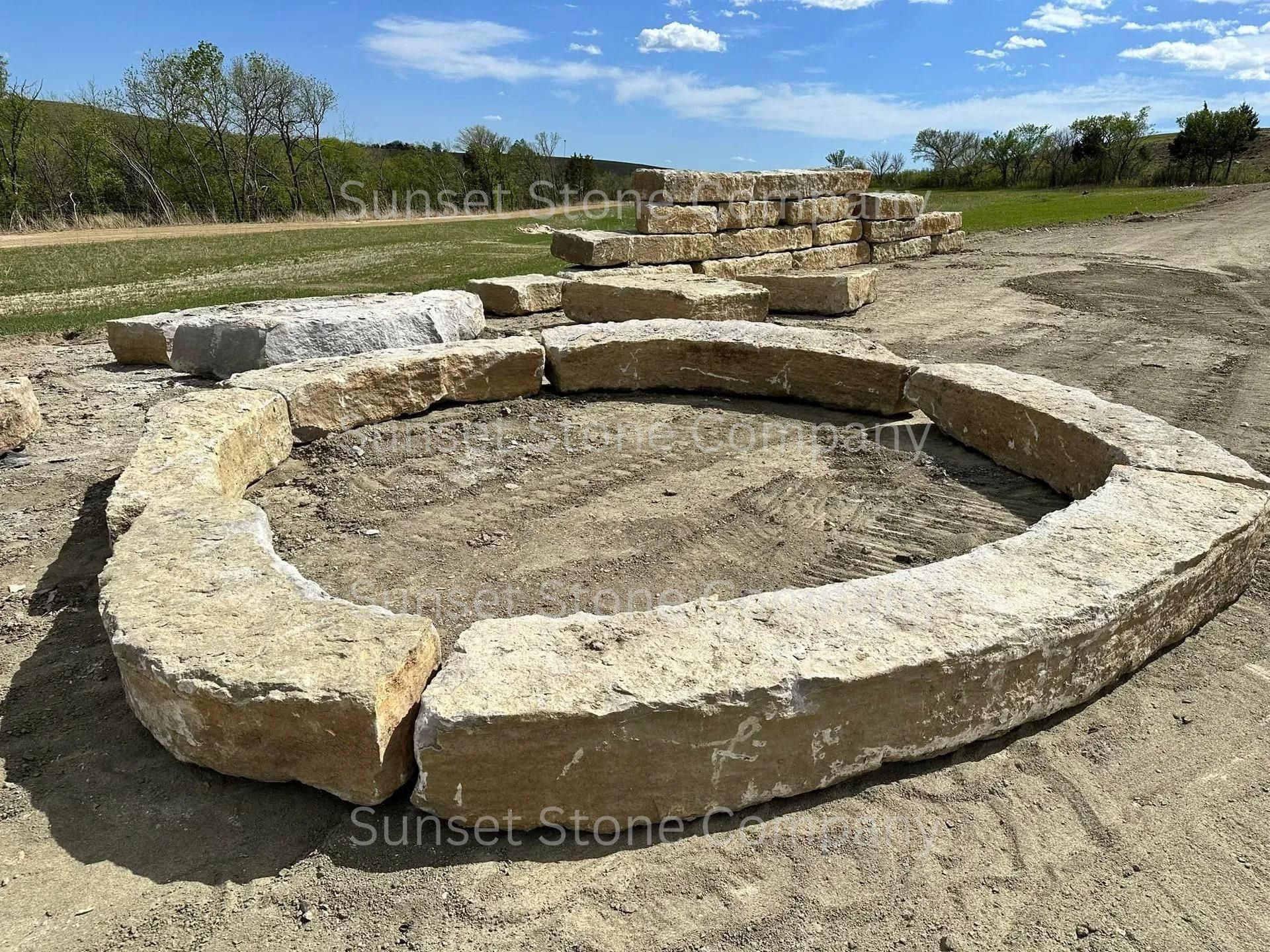 A large stone circle is sitting in the middle of a dirt field