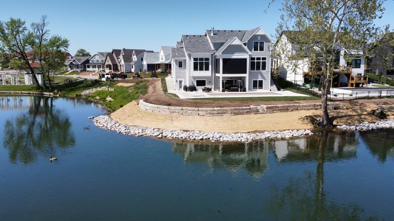 A large house is sitting on a small island in the middle of a lake.