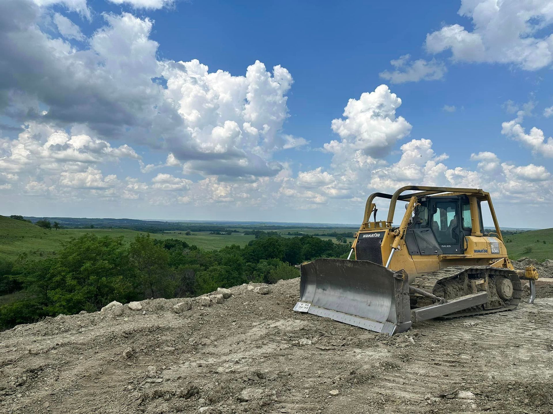 A bulldozer is sitting on top of a dirt hill.