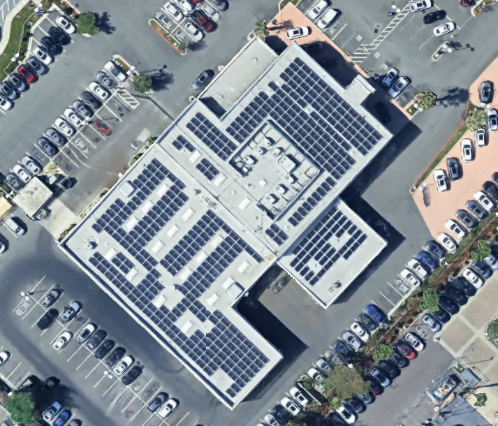 An aerial view of a building with solar panels on the roof