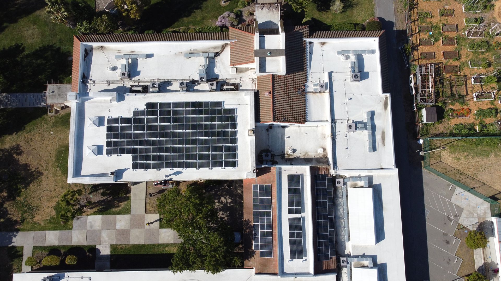An aerial view of a house with solar panels on the roof
