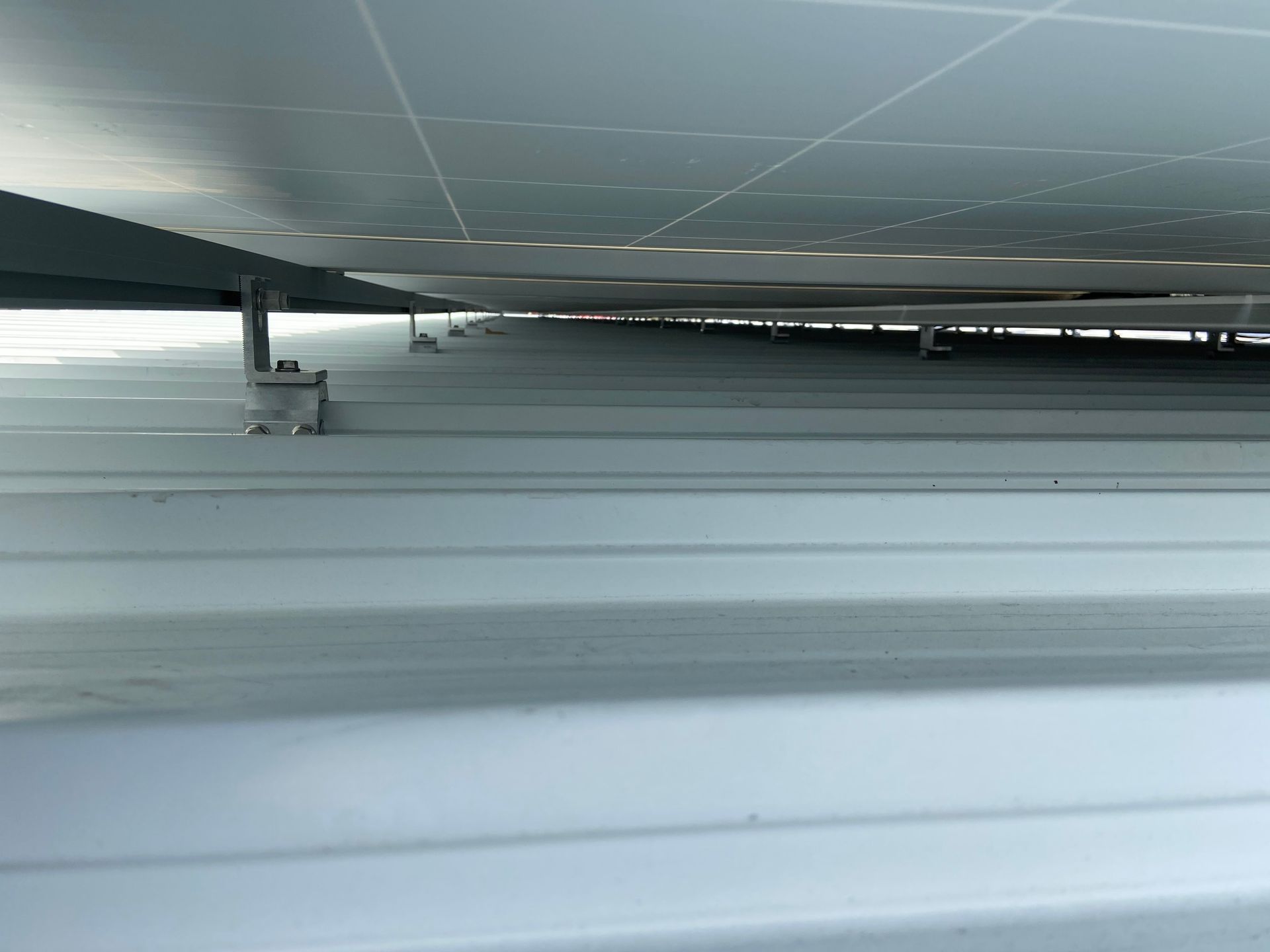 A row of solar panels are sitting on top of a metal roof.