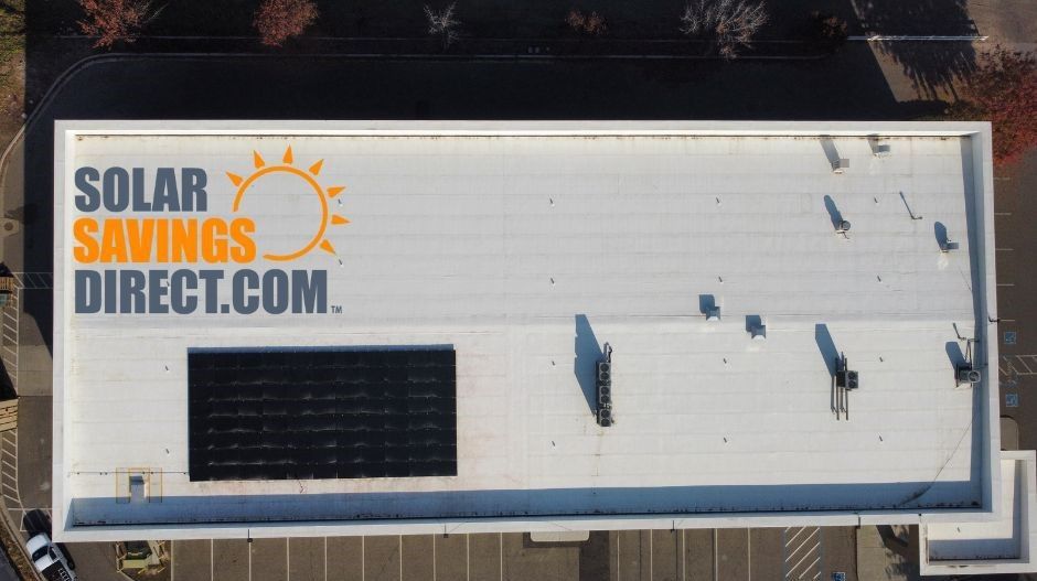 An aerial view of a building with solar panels on the roof.