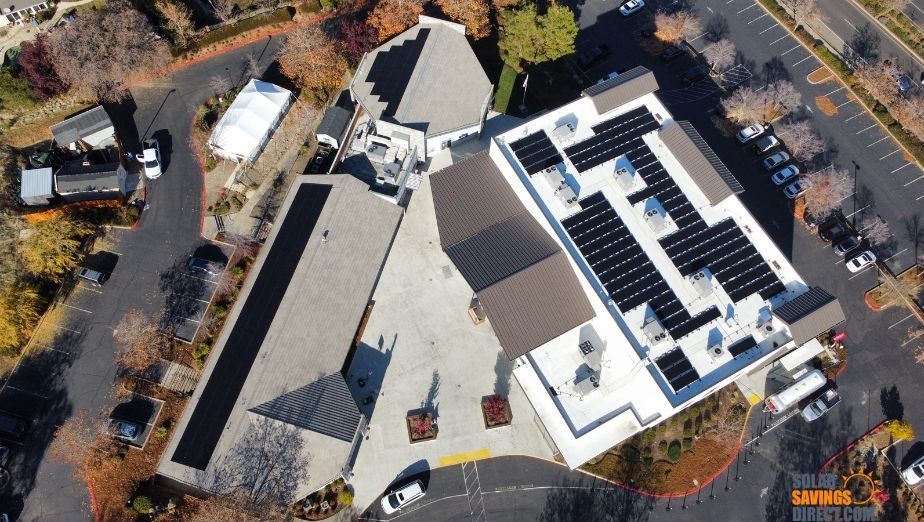 An aerial view of a building with solar panels on the roof.