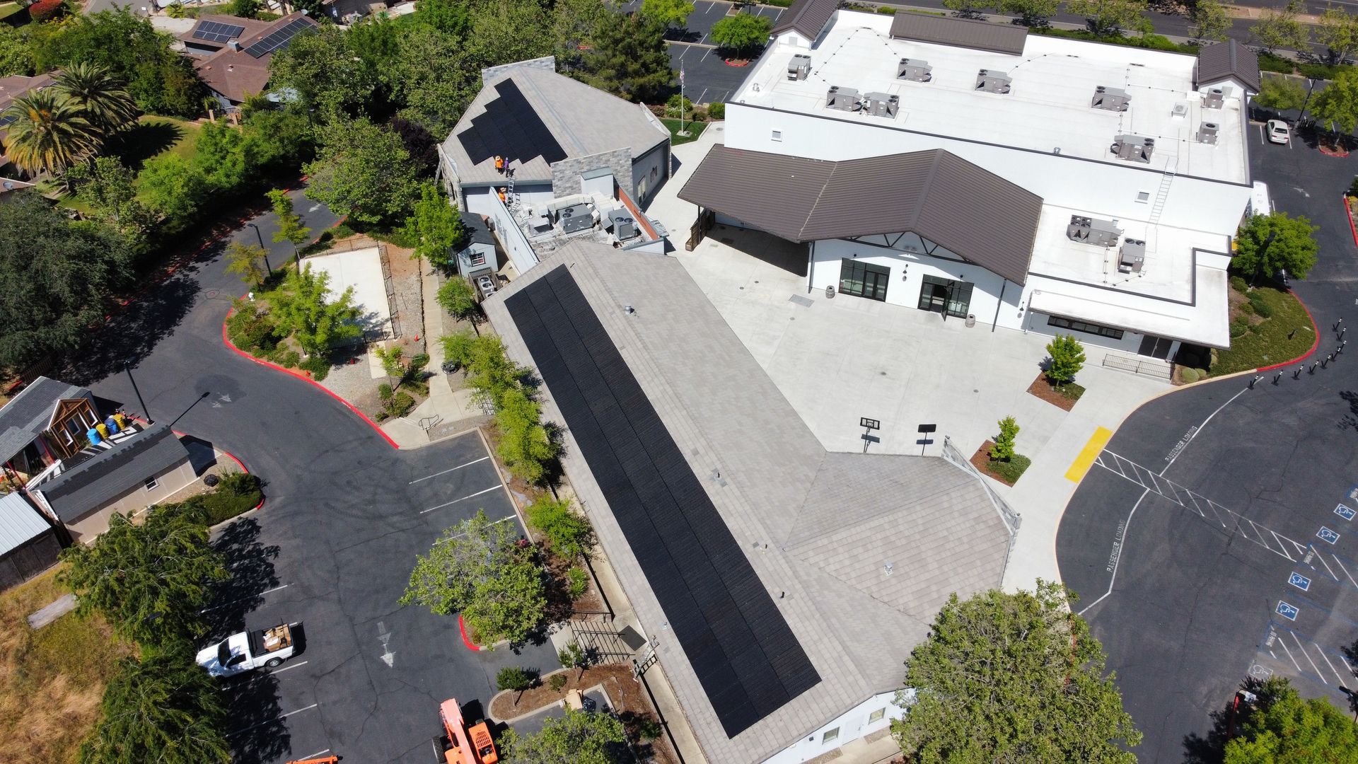 An aerial view of a large building with a large parking lot in front of it.