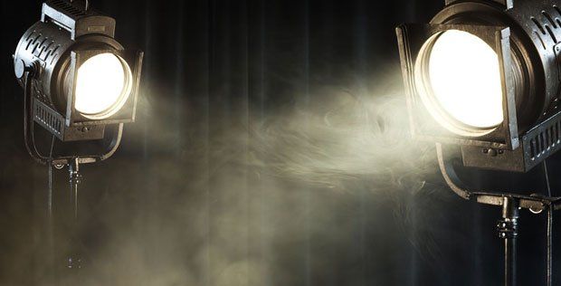 Theater spotlights on black curtain with smoke