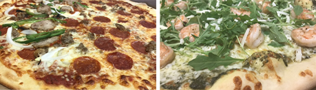 A pepperoni pizza and a shrimp pizza are sitting next to each other on a table.