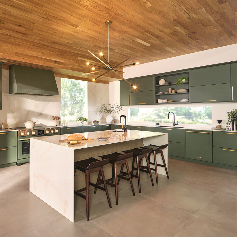 Modern green kitchen with wood ceiling, island with stools, and large window.