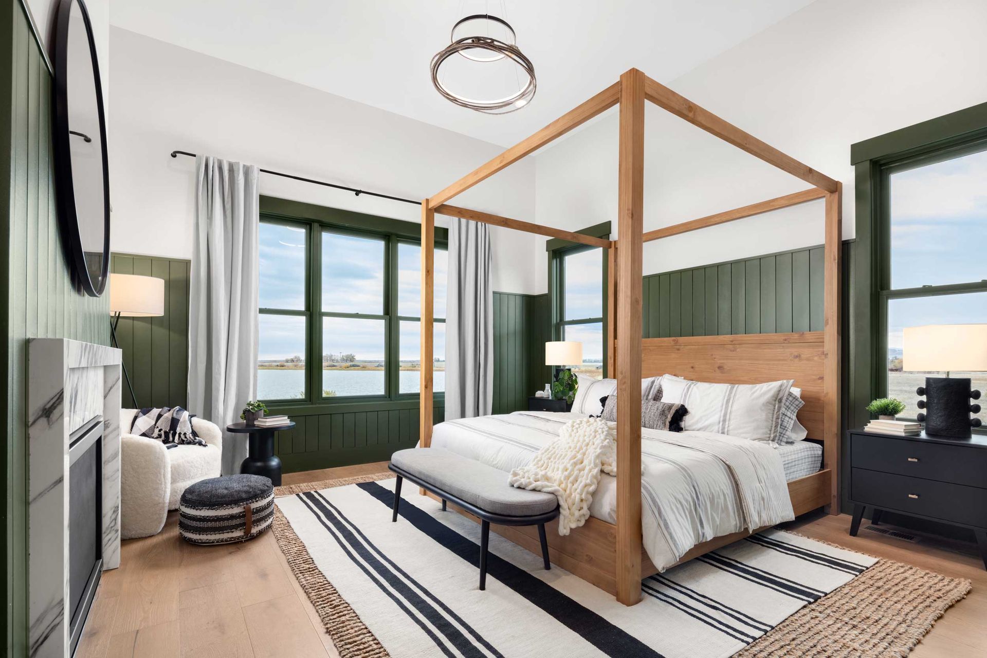 Bedroom with canopy bed, green trim, and black and white striped rug.