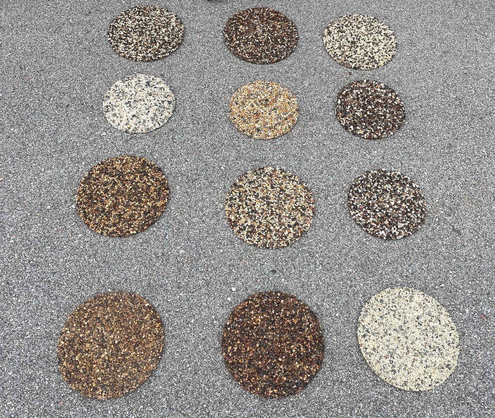 Twelve circular samples of various textured, multi-colored stone aggregate flooring arranged in four rows of three.