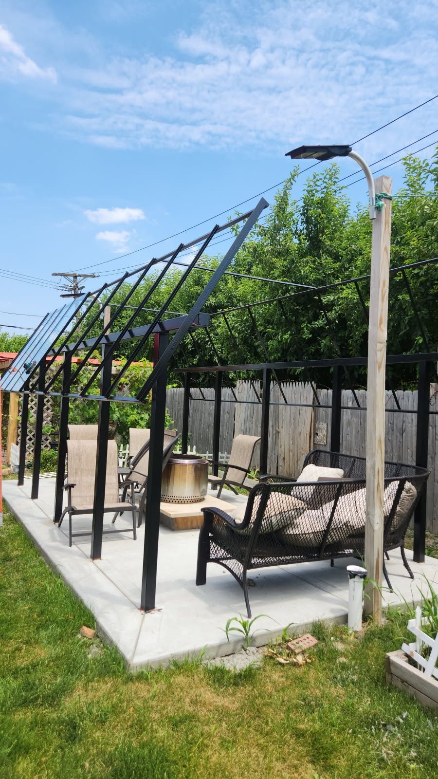 A patio with a couch , chairs , and a fire pit.