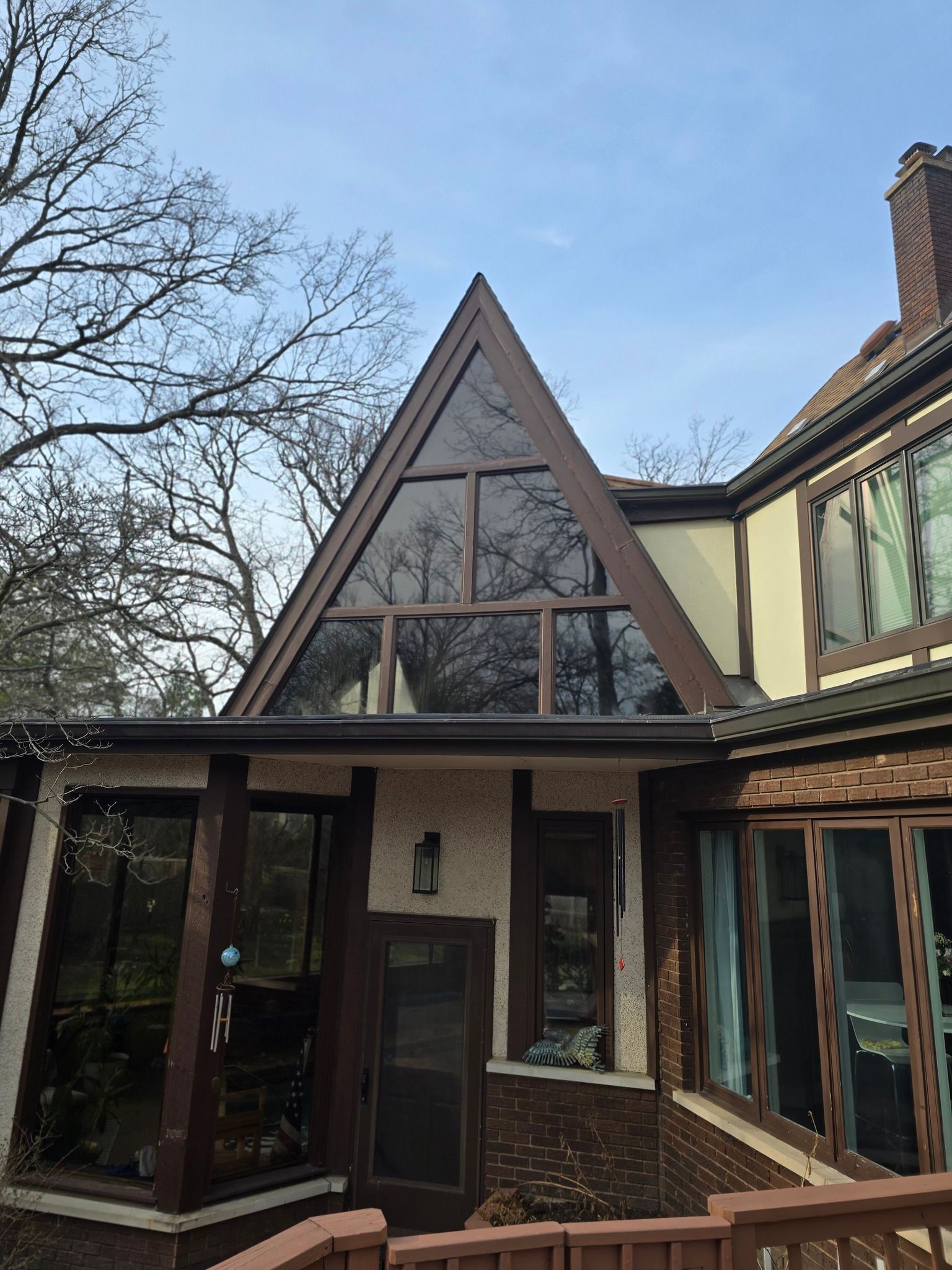 A house with a triangle shaped roof and a lot of windows.