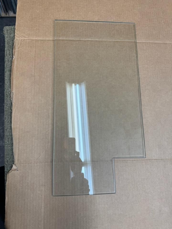 A piece of clear glass is sitting on top of a cardboard box.