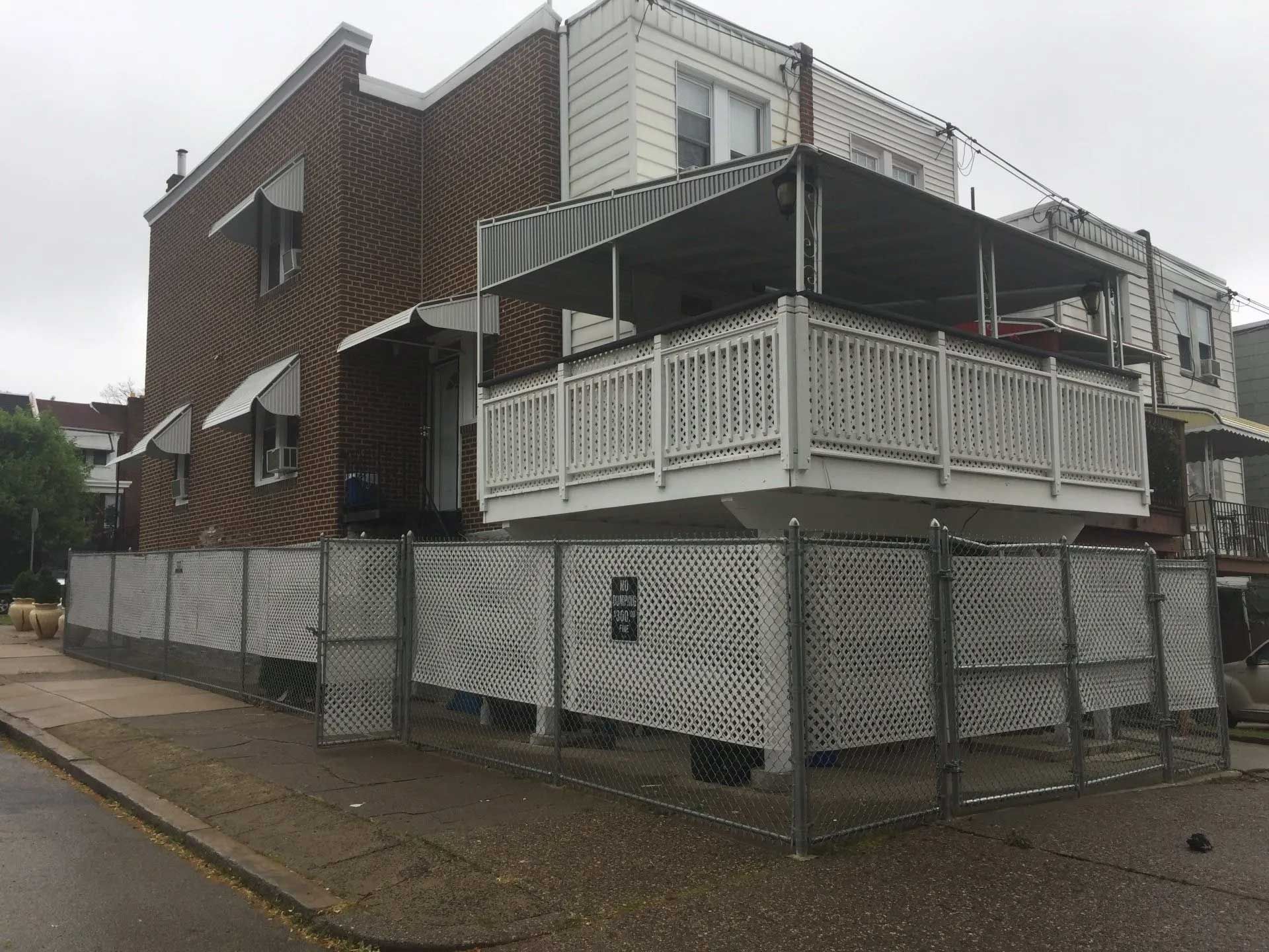 A house with a balcony and a fence around it.