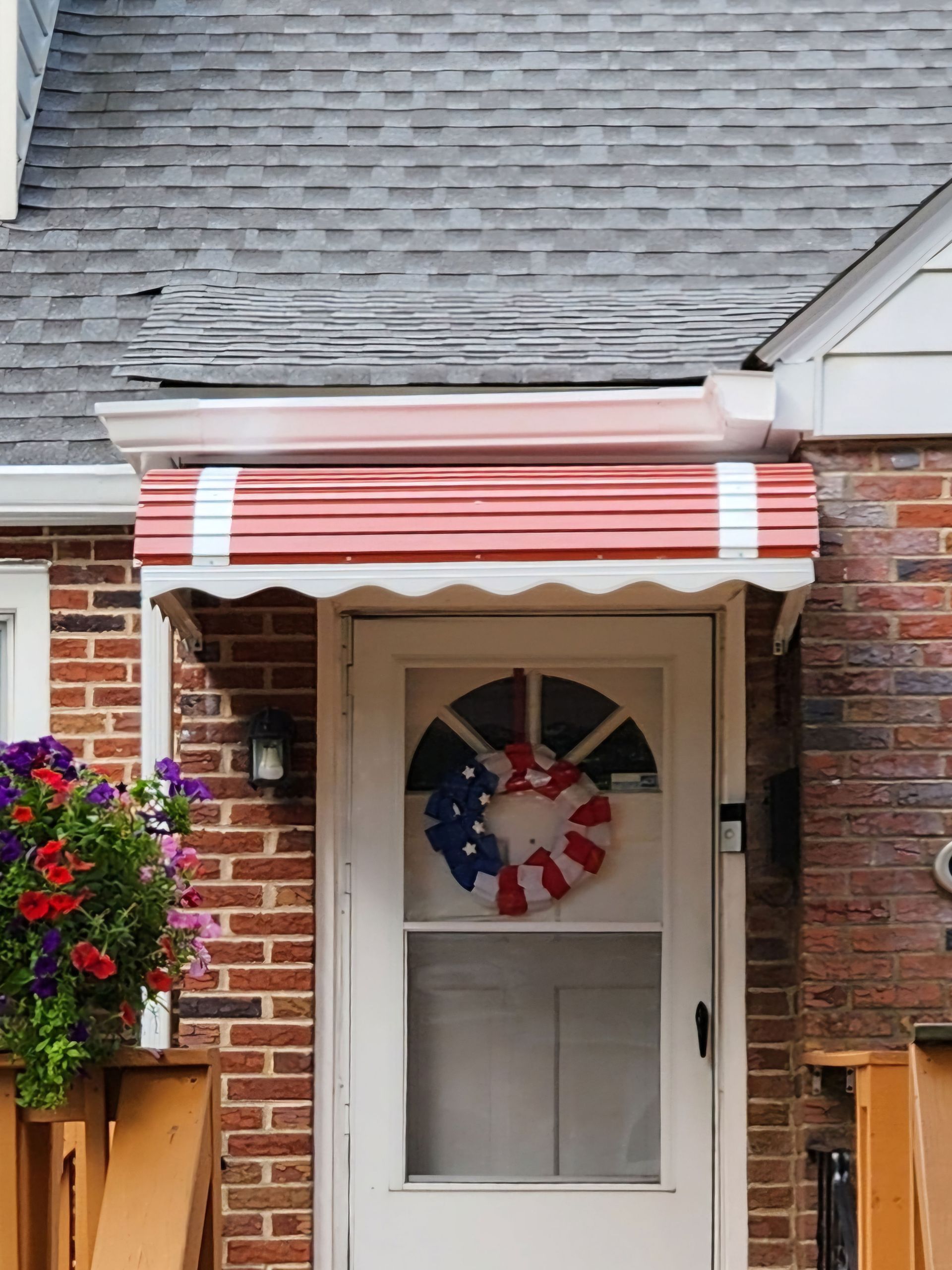 A white door with a red white and blue wreath on it.