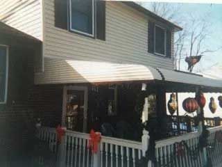 A house with a porch and a white awning on it.