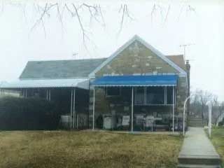 A house with a blue awning on the porch.