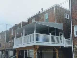 A house with a large deck and a carport underneath it.