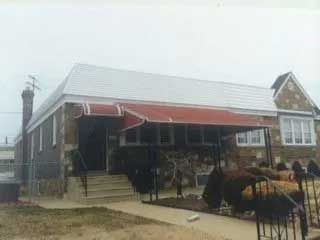 A house with a red awning on the front porch.