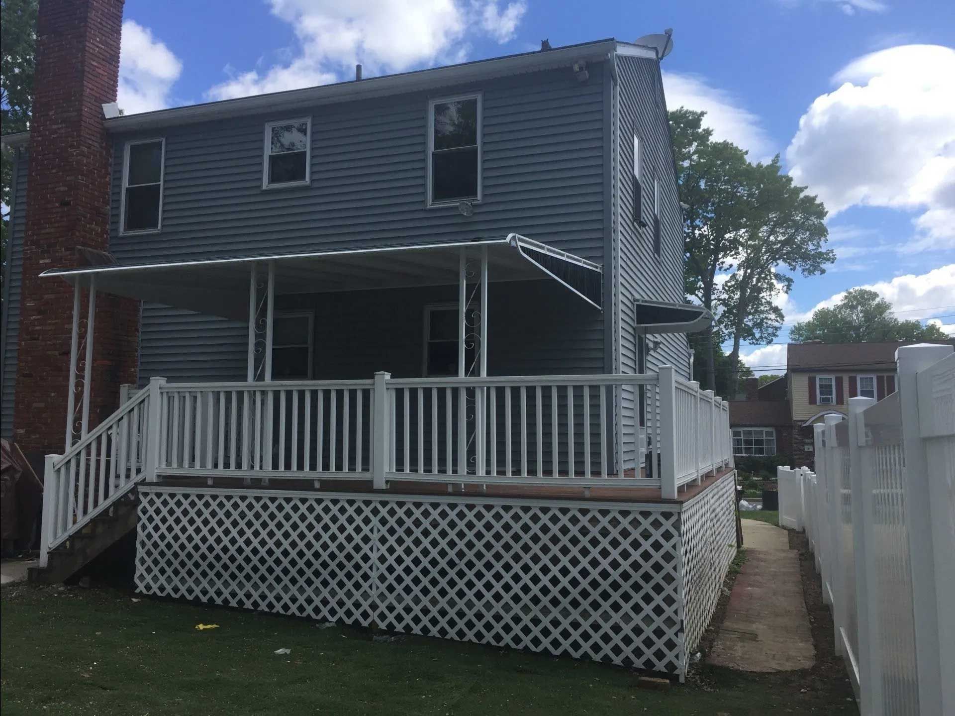 A house with a porch and a white fence