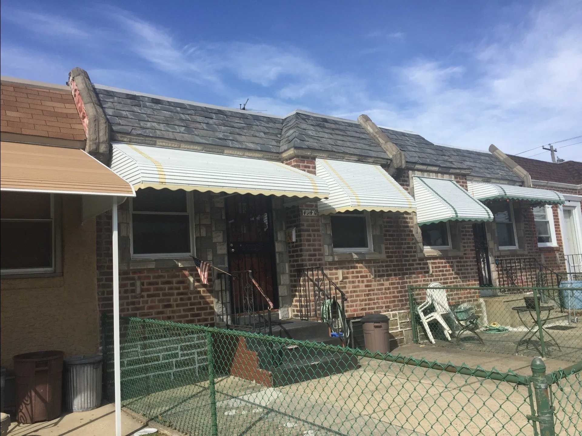 A row of brick houses with awnings on the porches.