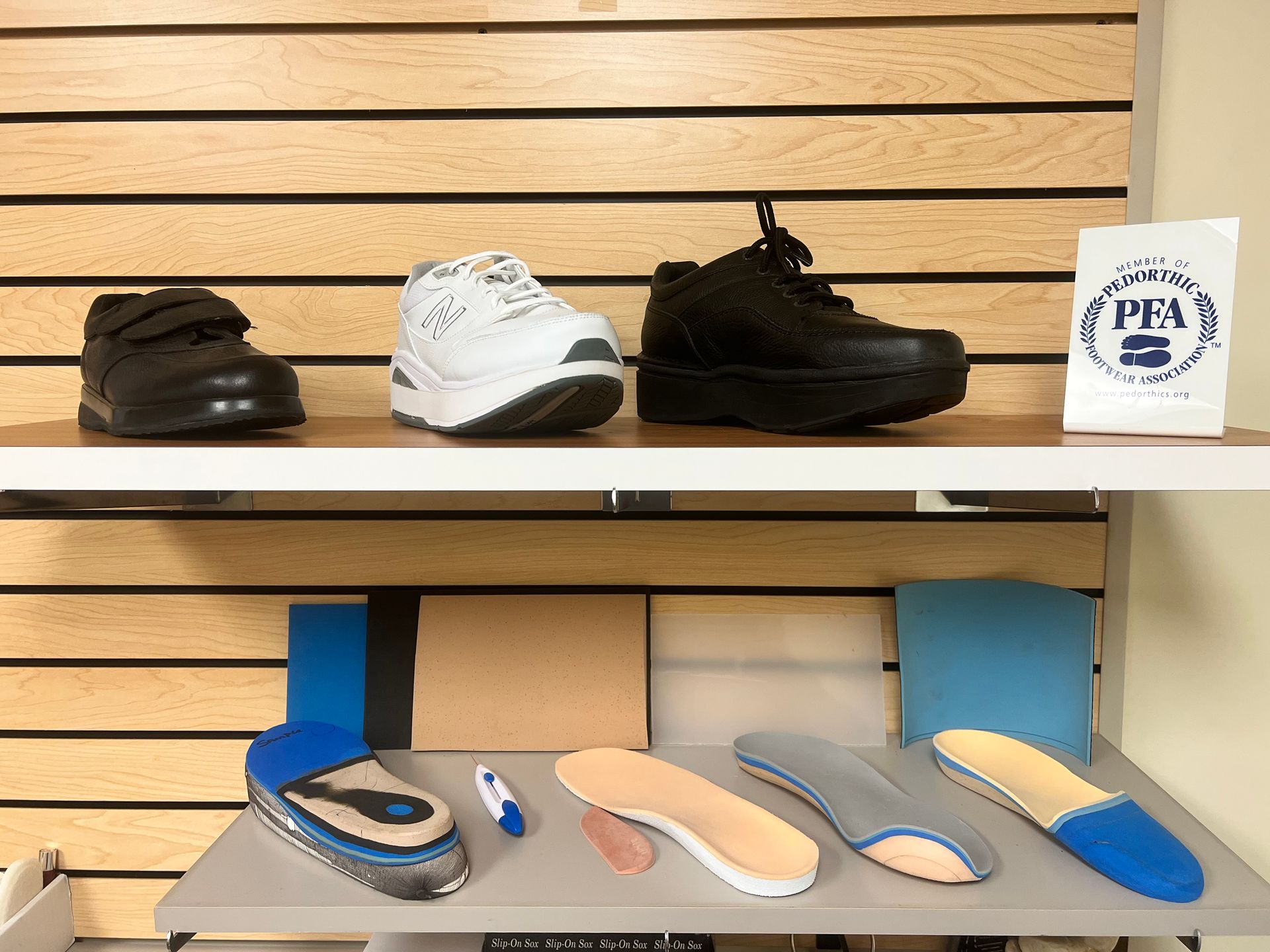 A shelf with shoes and insoles on it in a store.