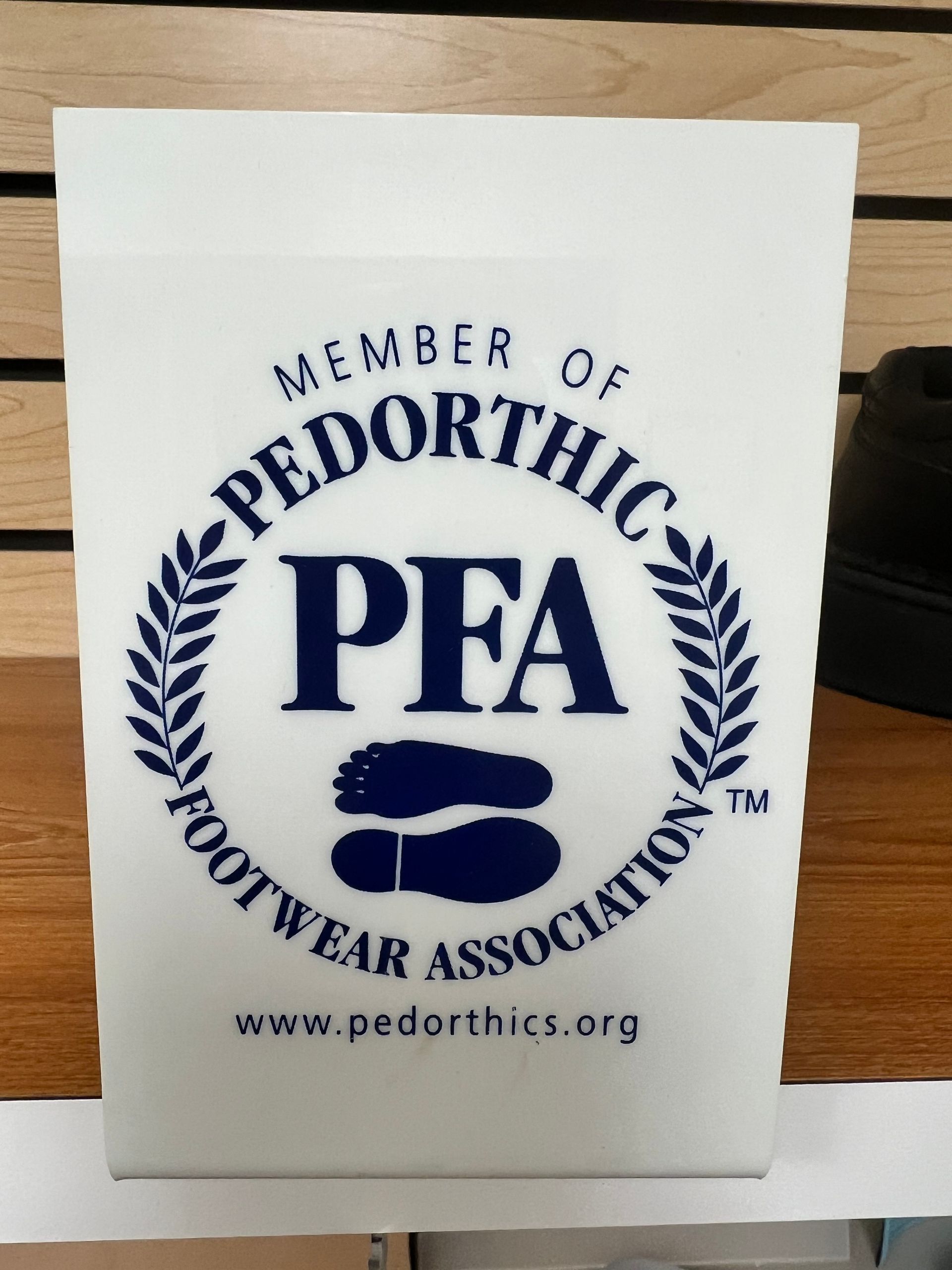 A white sign that says member of pedorthic footwear association
