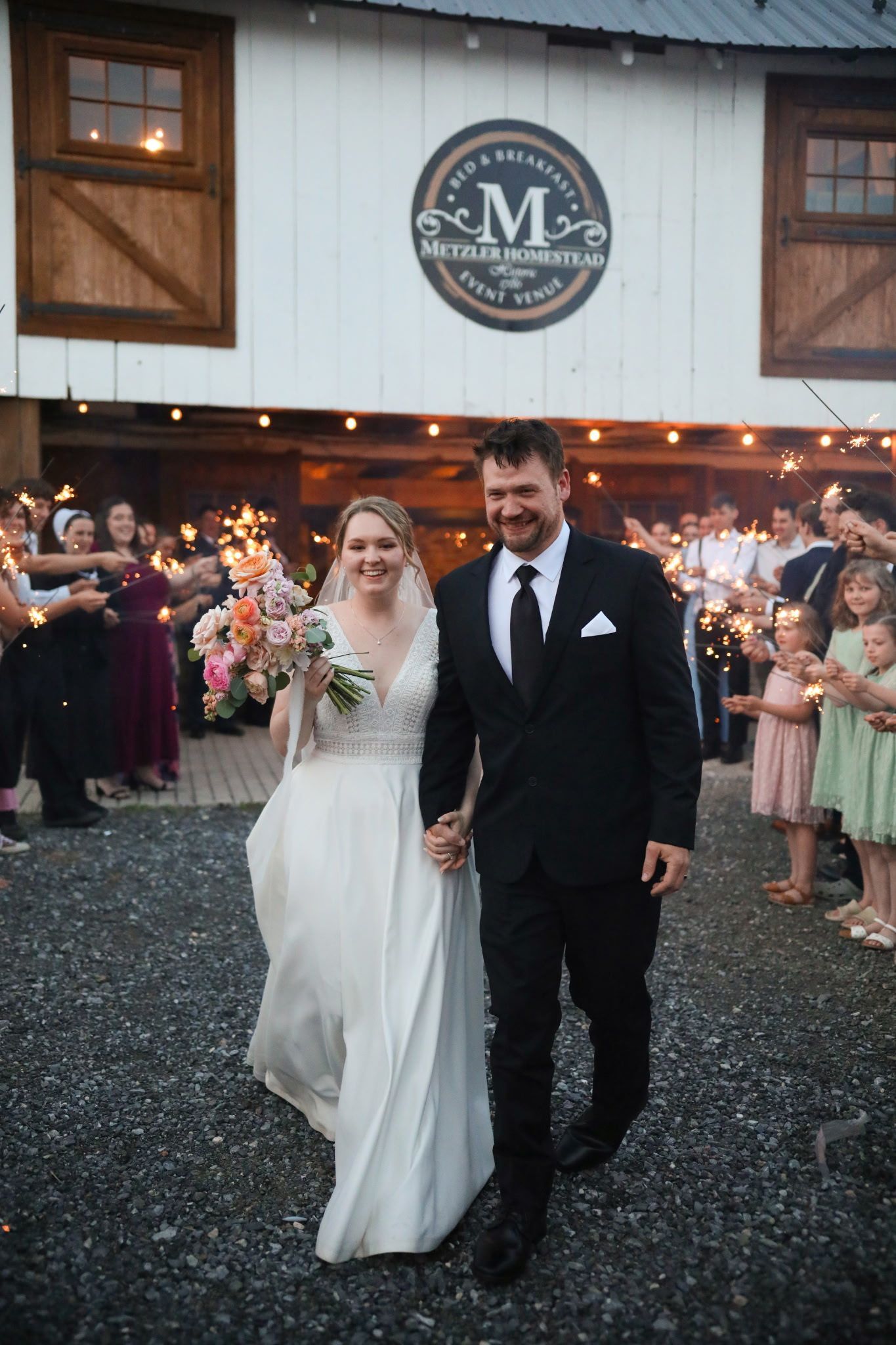 Newlyweds walking down an aisle, guests cheering on both sides