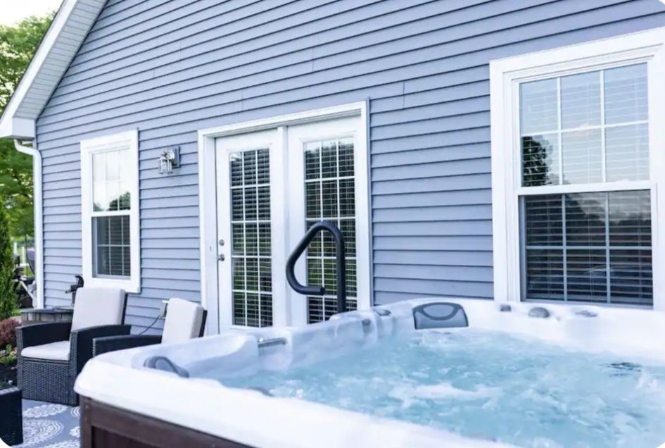 A hot tub is sitting in front of a house.