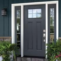 Front entrance with a dark gray door, narrow sidelights, and green plants beside a blue exterior wall.