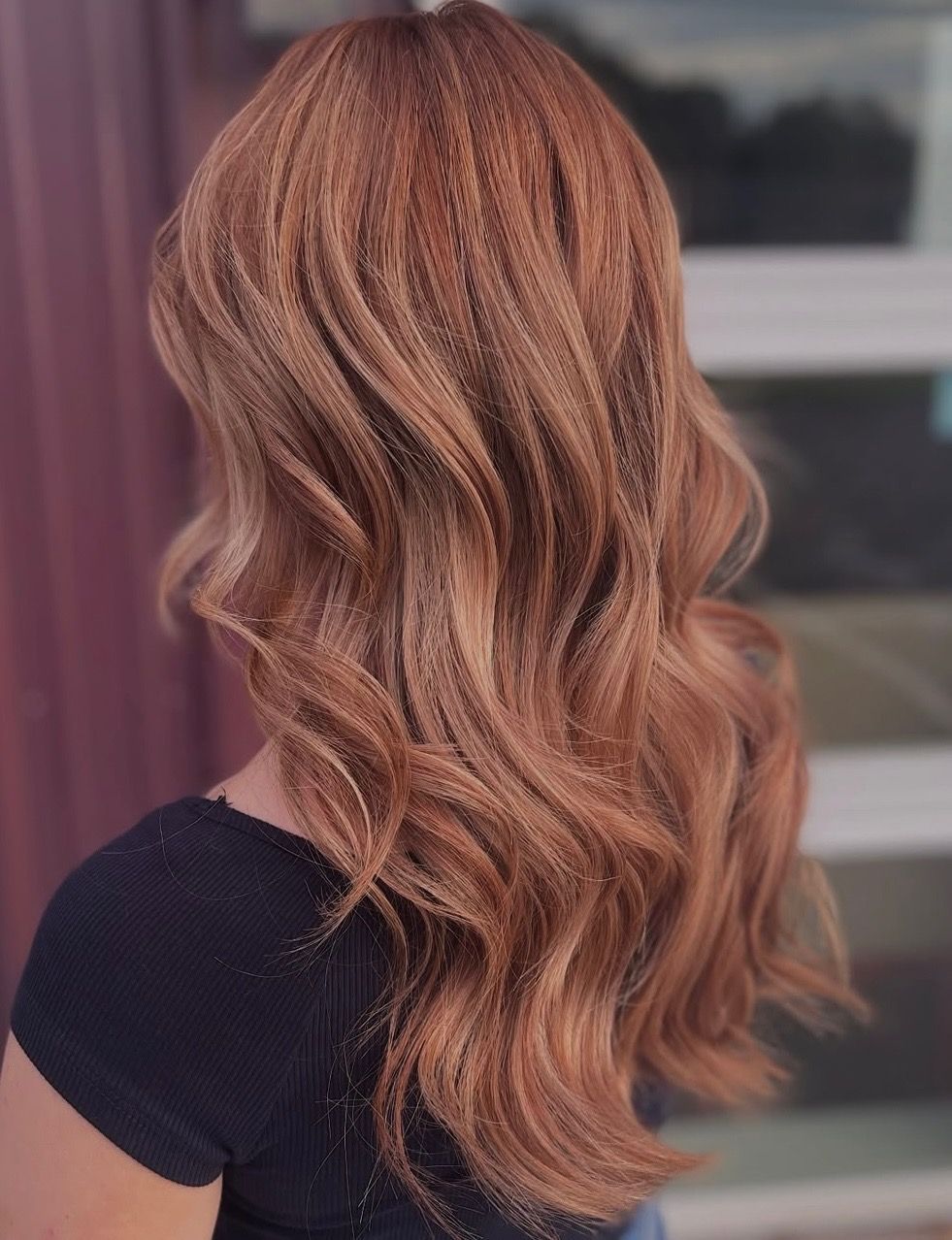 Woman with long, wavy auburn hair. Back view.