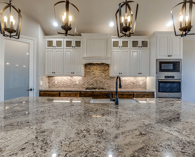 Bright modern kitchen with granite island, white cabinets, pendant lights, and stainless steel appliances