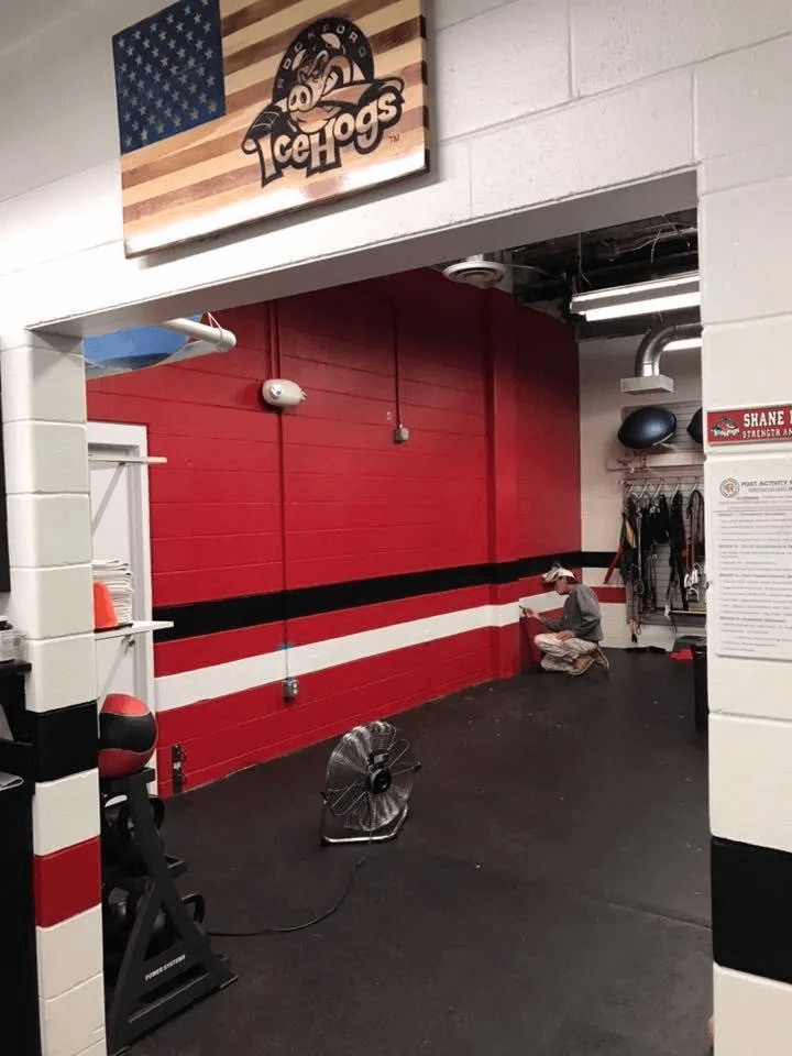 Gym interior with red wall, black floor, and Ice Dogs sign above the doorway