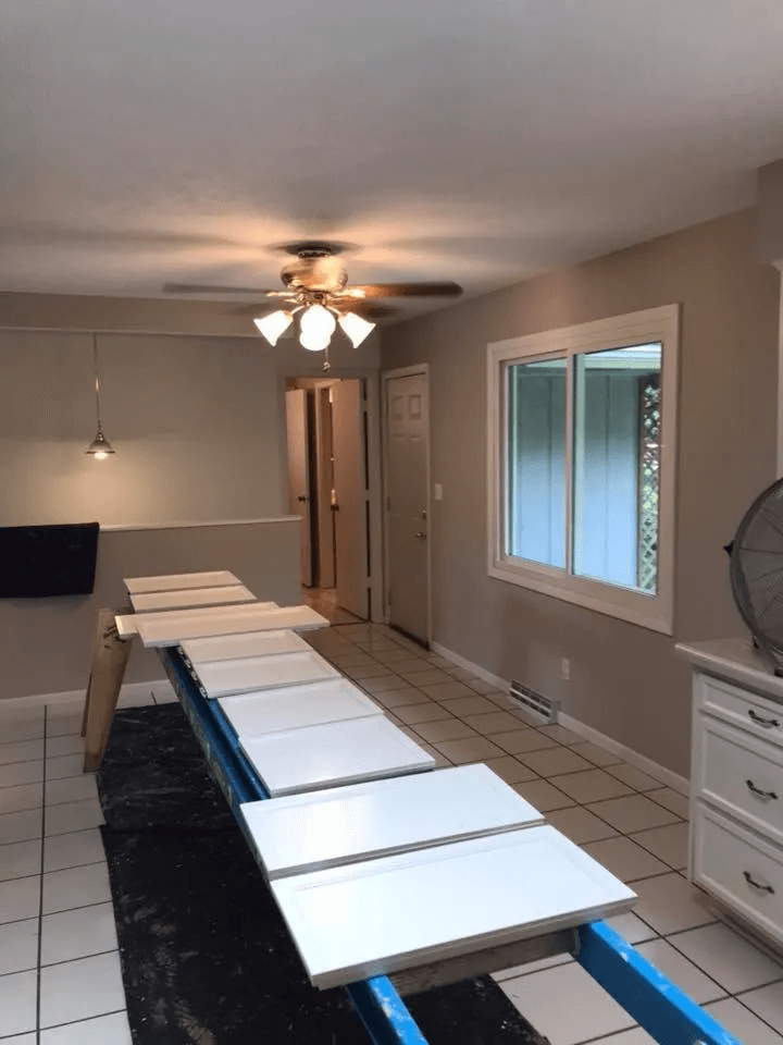 Dining room with a long folding table setup, ceiling fan light, and a window with blinds.