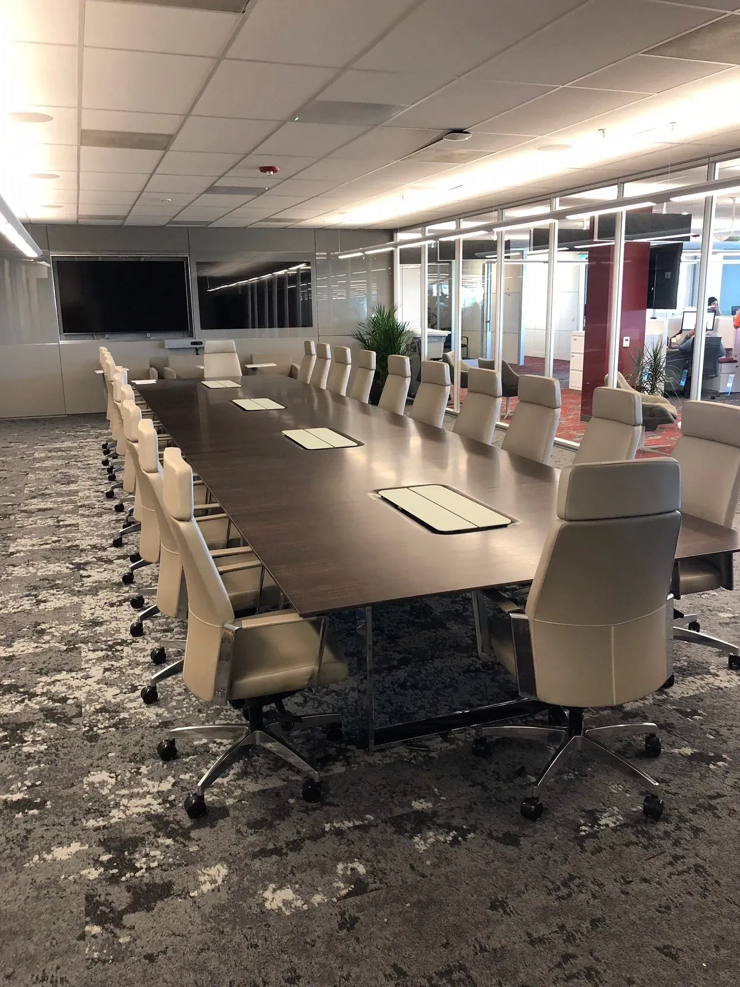 Conference room with long table, white chairs, and carpeted floor after damage or flooding.