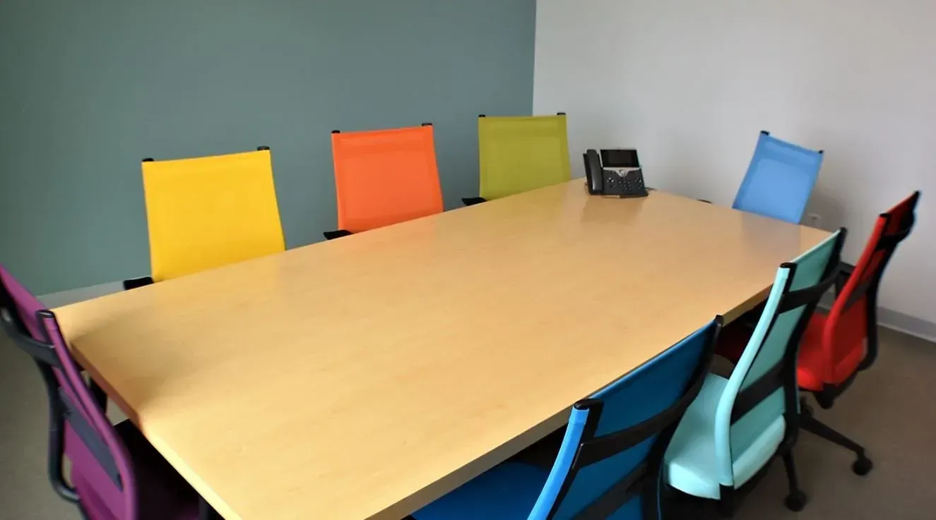 Conference table with colorful chairs around it in a meeting room
