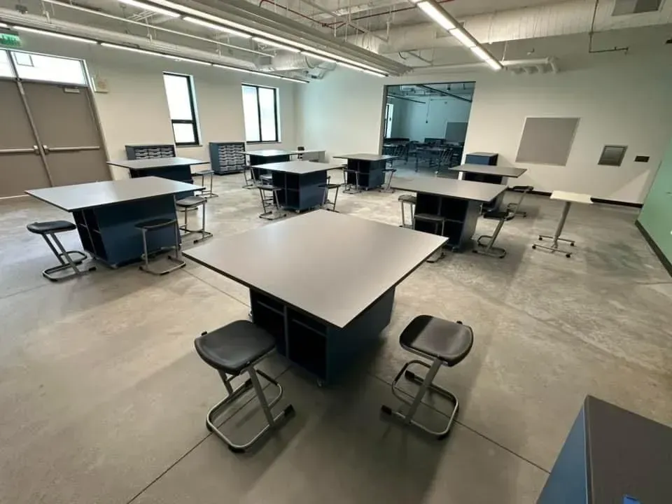 Empty classroom with tables and stools in a bright, modern room