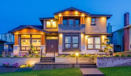 A large house with a lot of windows is lit up at night.