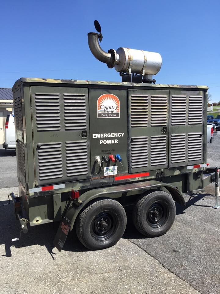 A trailer with a generator on it is parked on the side of the road.