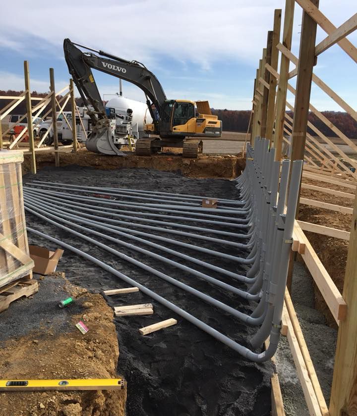 A construction site with a Volvo excavator in the background.