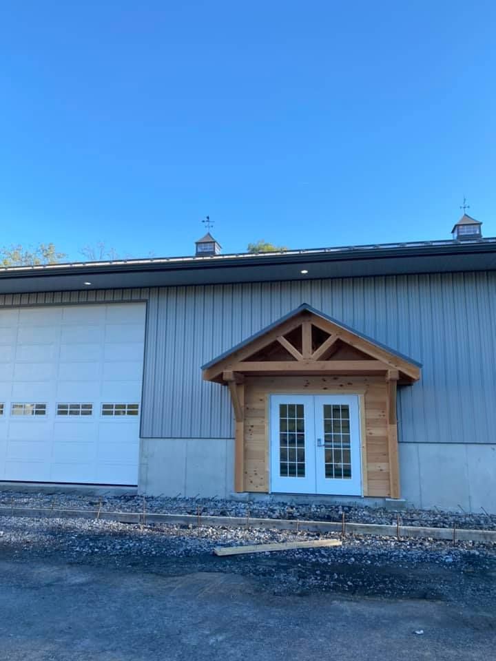 A large building with a garage door and a wooden porch.