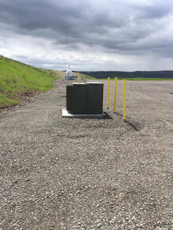 A gravel road with a black box in the middle of it.