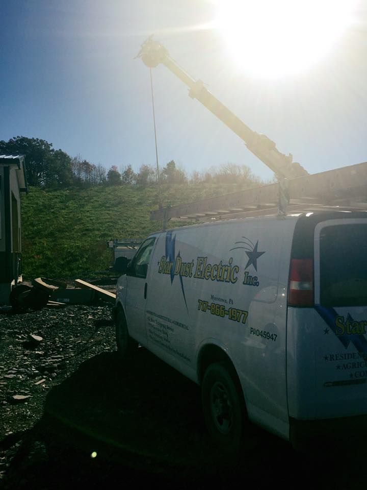 A white van with a crane on top of it.