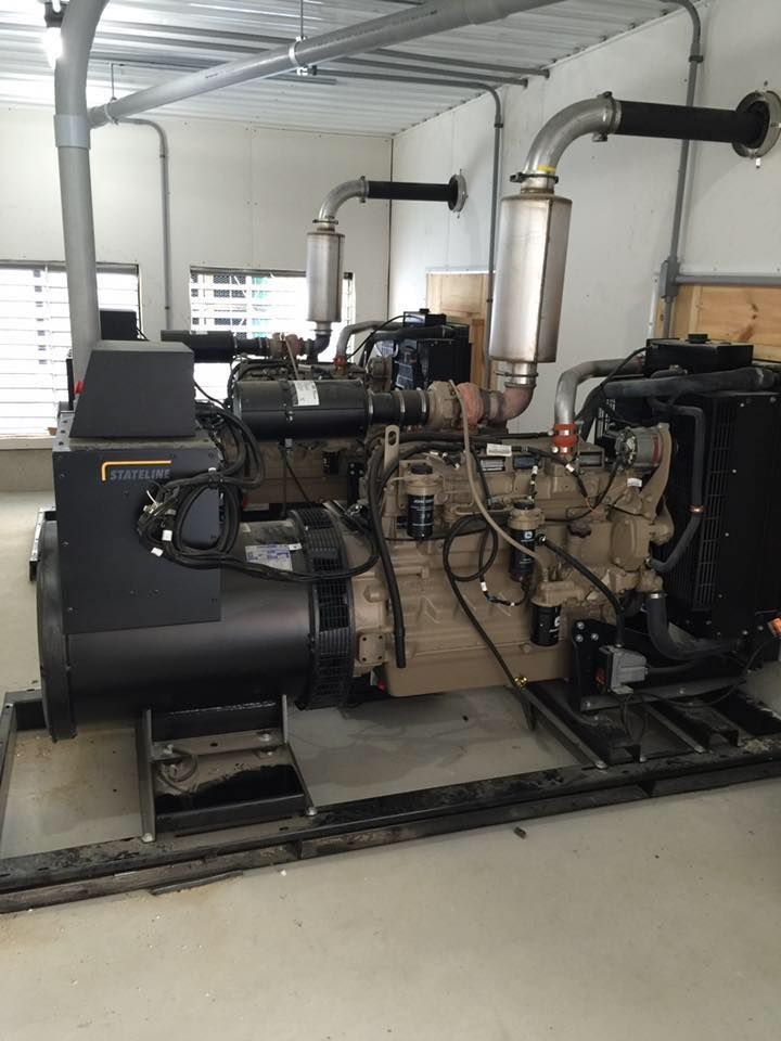A large diesel generator is sitting inside of a building.