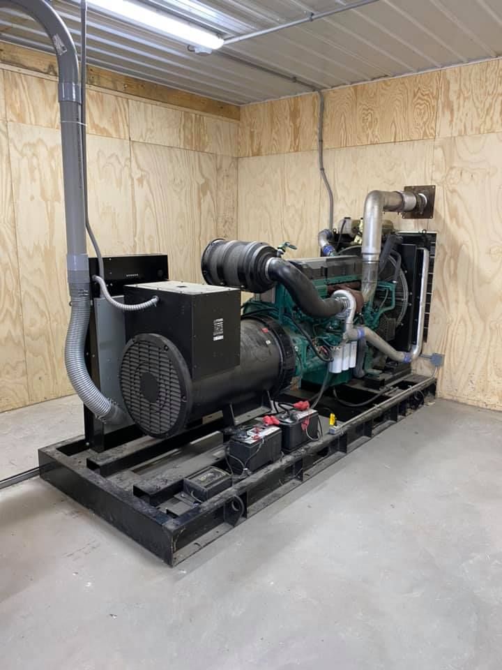 A large diesel generator is sitting in a room.