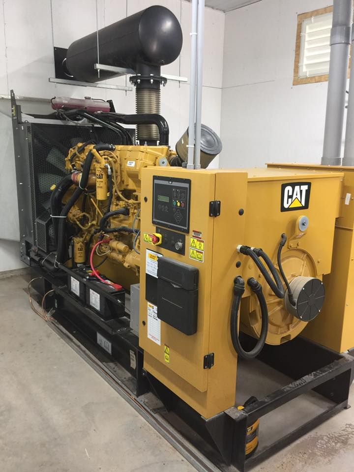 A cat diesel generator is sitting in a room.