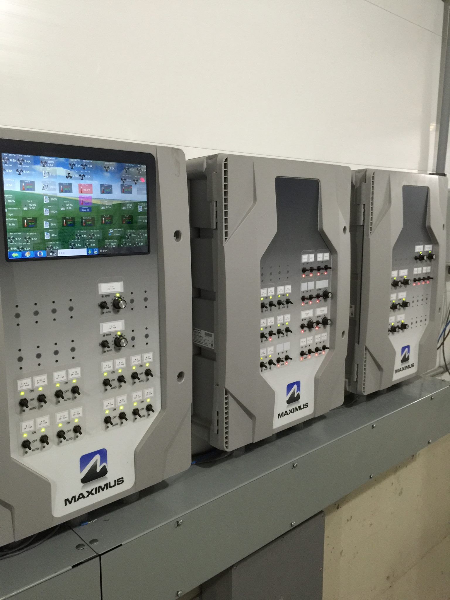 A row of control panels with a monitor on top of them.