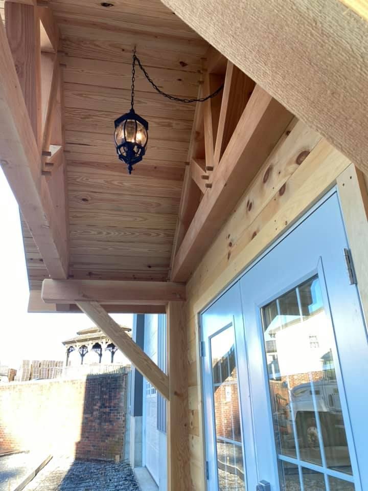 A wooden porch with a light hanging from the ceiling.