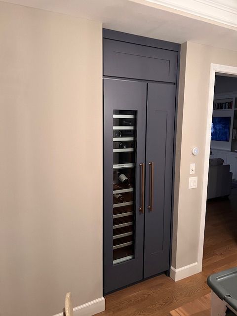 Built-in wine refrigerator with dark blue doors 